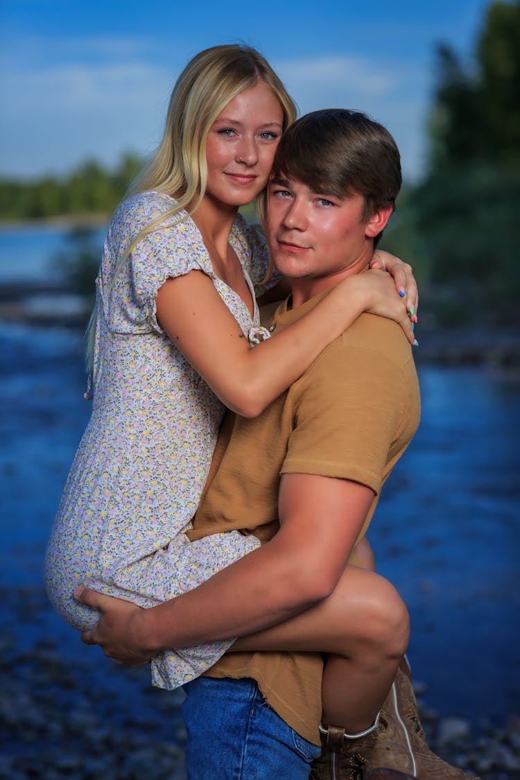 Man Carrying A Blonde Woman In Floral Dress