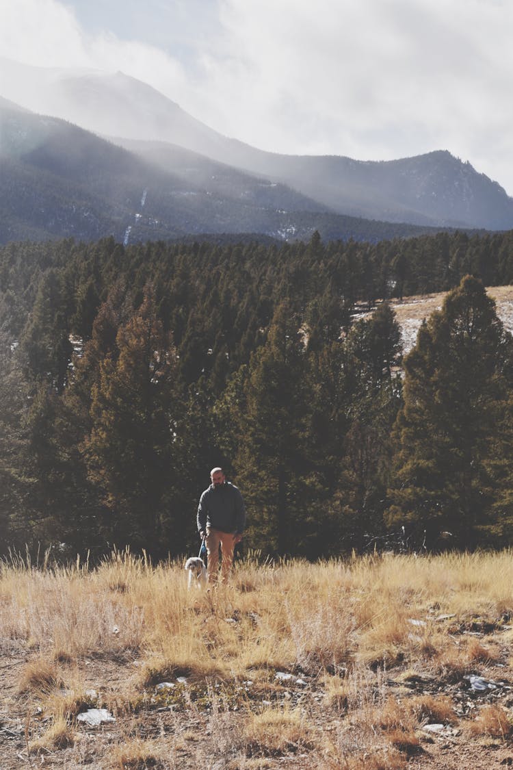 A Man Walking With A Dog 