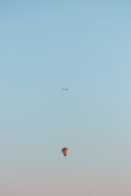 Plane Flying over a Balloon in the Sky 