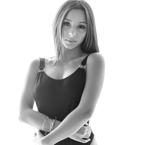 A Grayscale Photo of a Woman in Black Tank Top Looking with a Serious Face
