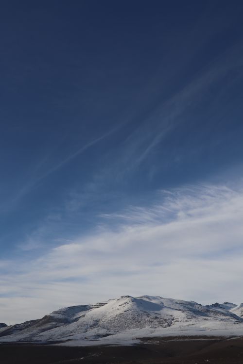 Free Breathtaking view of a snow-covered mountain range under a clear blue sky. Stock Photo