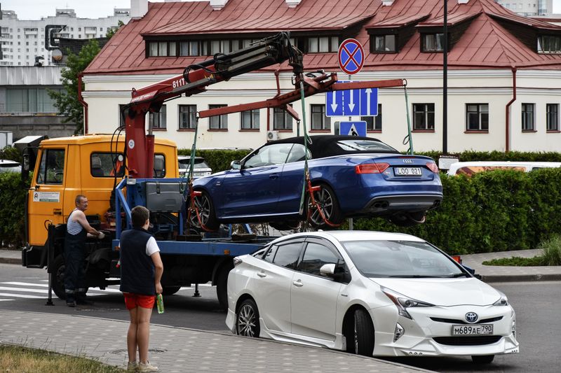 Premier Towing & Recovery truck loading a disabled car