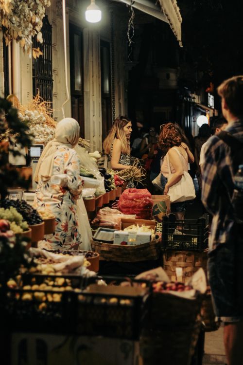 Free A lively night market scene with vendors and shoppers under warm urban lighting. Stock Photo