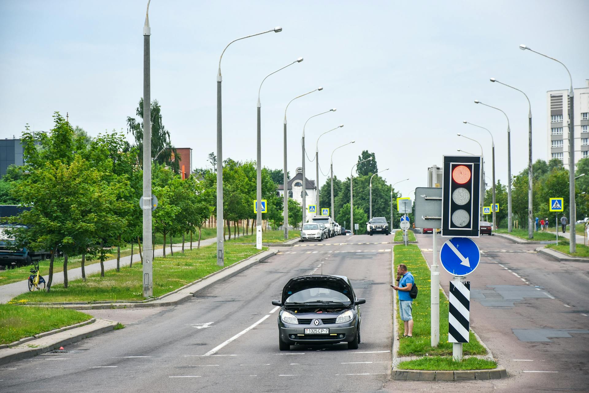 Man Standing near Broken Car on Road