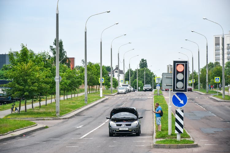 Man Standing Near Broken Car On Road