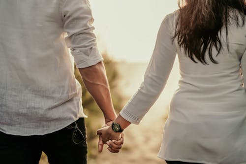 A Couple Holding Hands While Walking