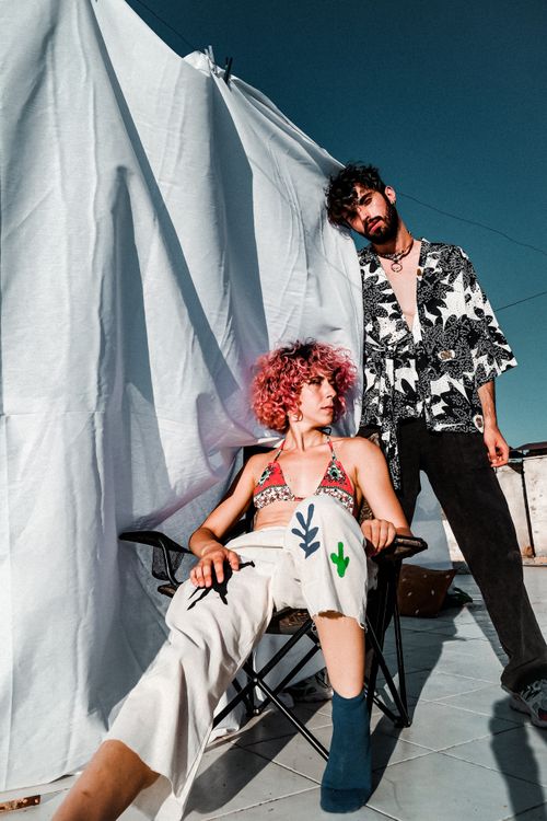 Free A fashionable couple posing outdoors during summer in vibrant outfits. Stock Photo