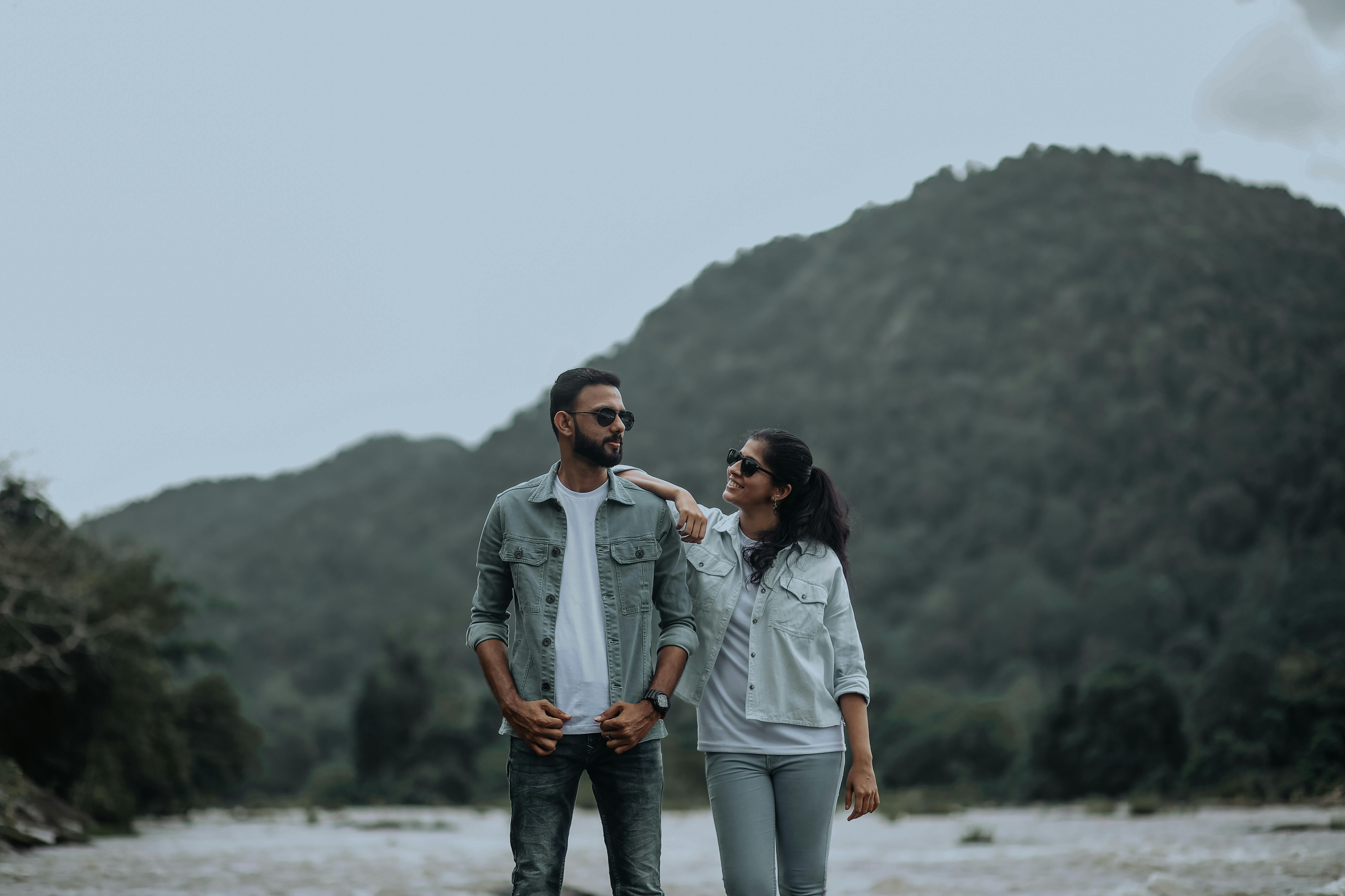 Premium Photo  Fashionable beautiful young stylish couple woman and  handsome man with vintage sunglasses in fashion clothes with jeans jacket  and leather black coat standing near the wall trendy urban casual