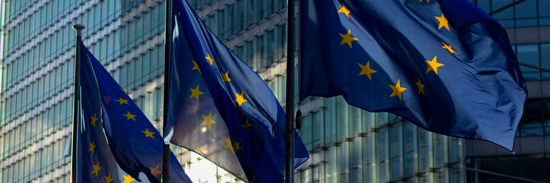 EU flags waving in front of the European Commission building in Brussels, Belgium.