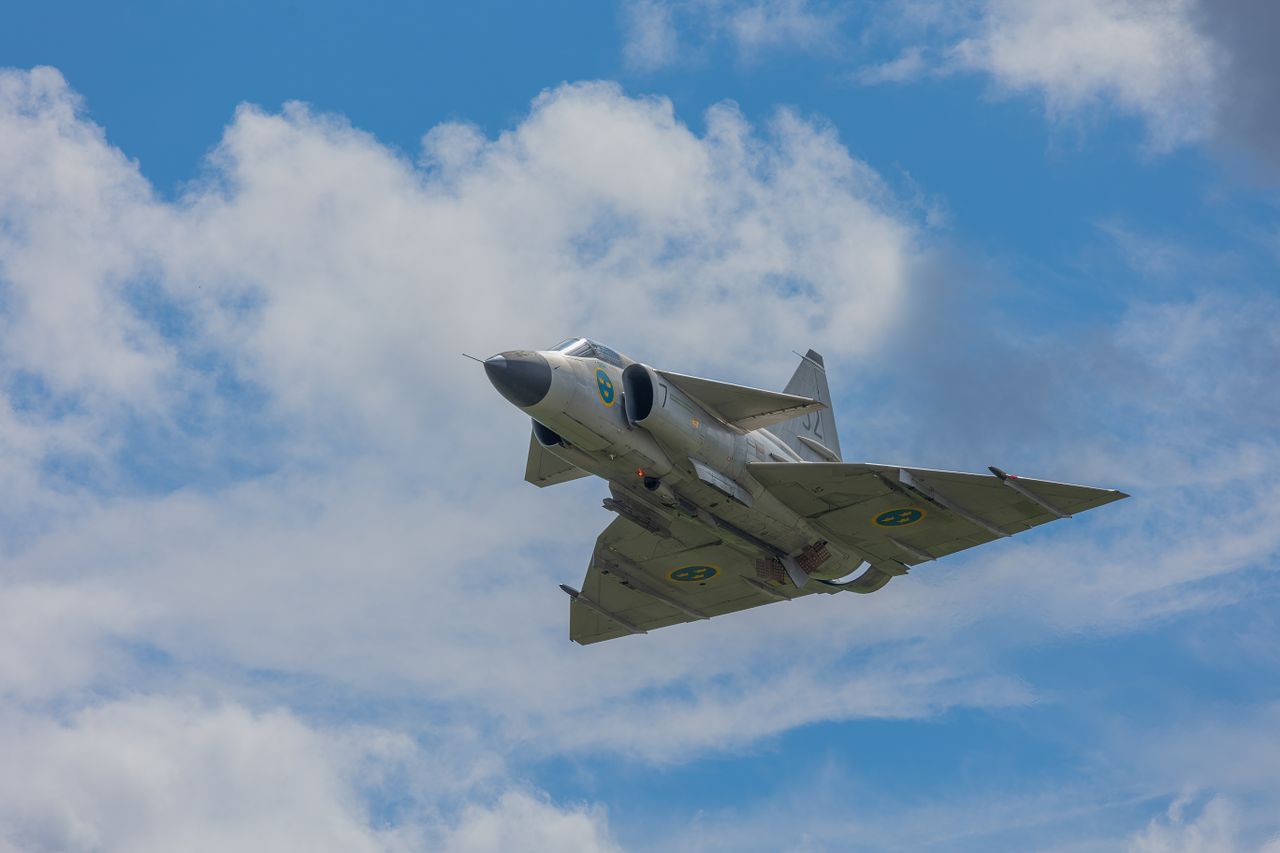 a majestic fighter jet flying through a clear blue sky demonstrating s