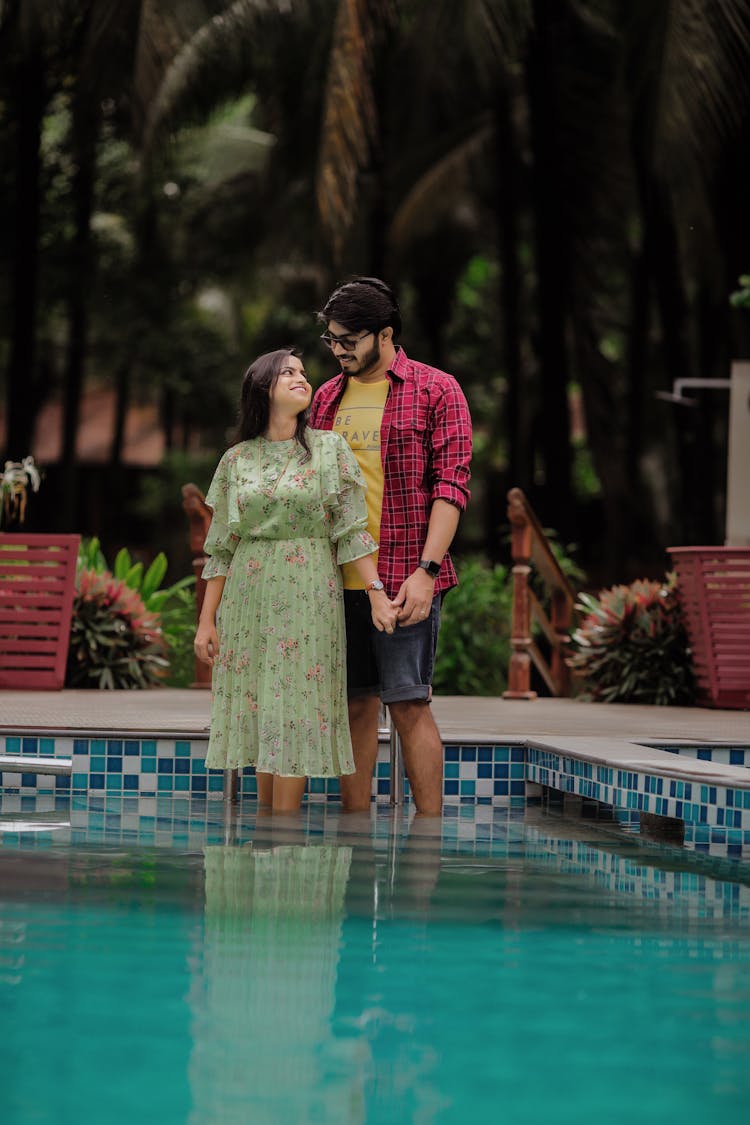 Couple Holding Hands Standing In Pool