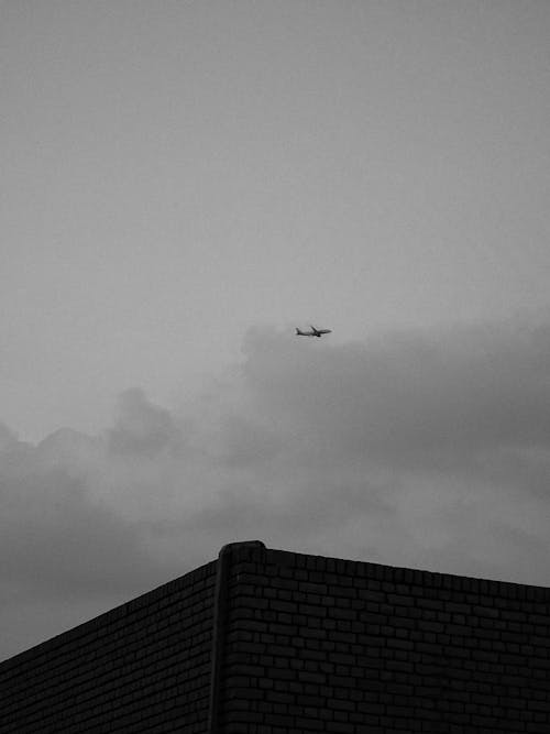 Grayscale Photo of an Airplane Flying on Sky