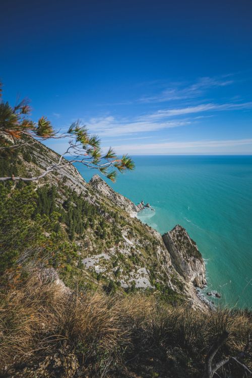 Free Stunning view of rugged coastal cliffs with azure sea under a clear sky. Stock Photo