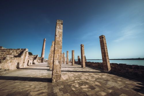 Free Explore the ancient stone pillars of the Tonnara of Vendicari in Italy's nature reserve under a clear blue sky. Stock Photo