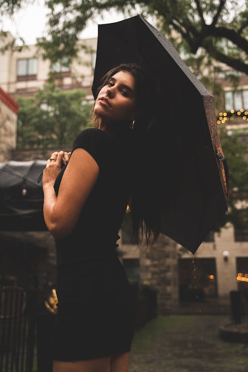 A Woman in Black Dress Holding a Black Umbrella
