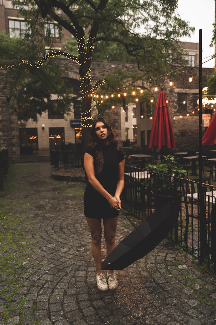 Woman In Black Dress Holding An Umbrella