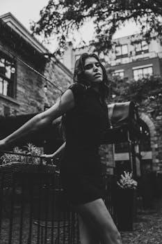 Elegant black and white portrait of a woman standing in an outdoor urban setting in Ottawa.