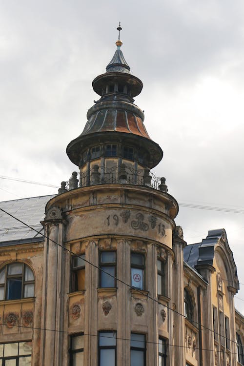 A Low Angle Shot of a Building with Glass Windows Under the Cloudy Sky