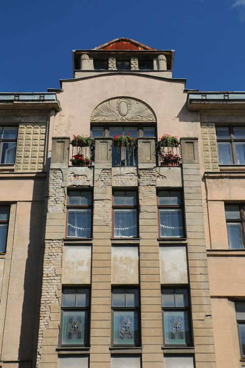 Free Close-up of a vintage urban building facade with decorative flowers and unique architecture. Stock Photo