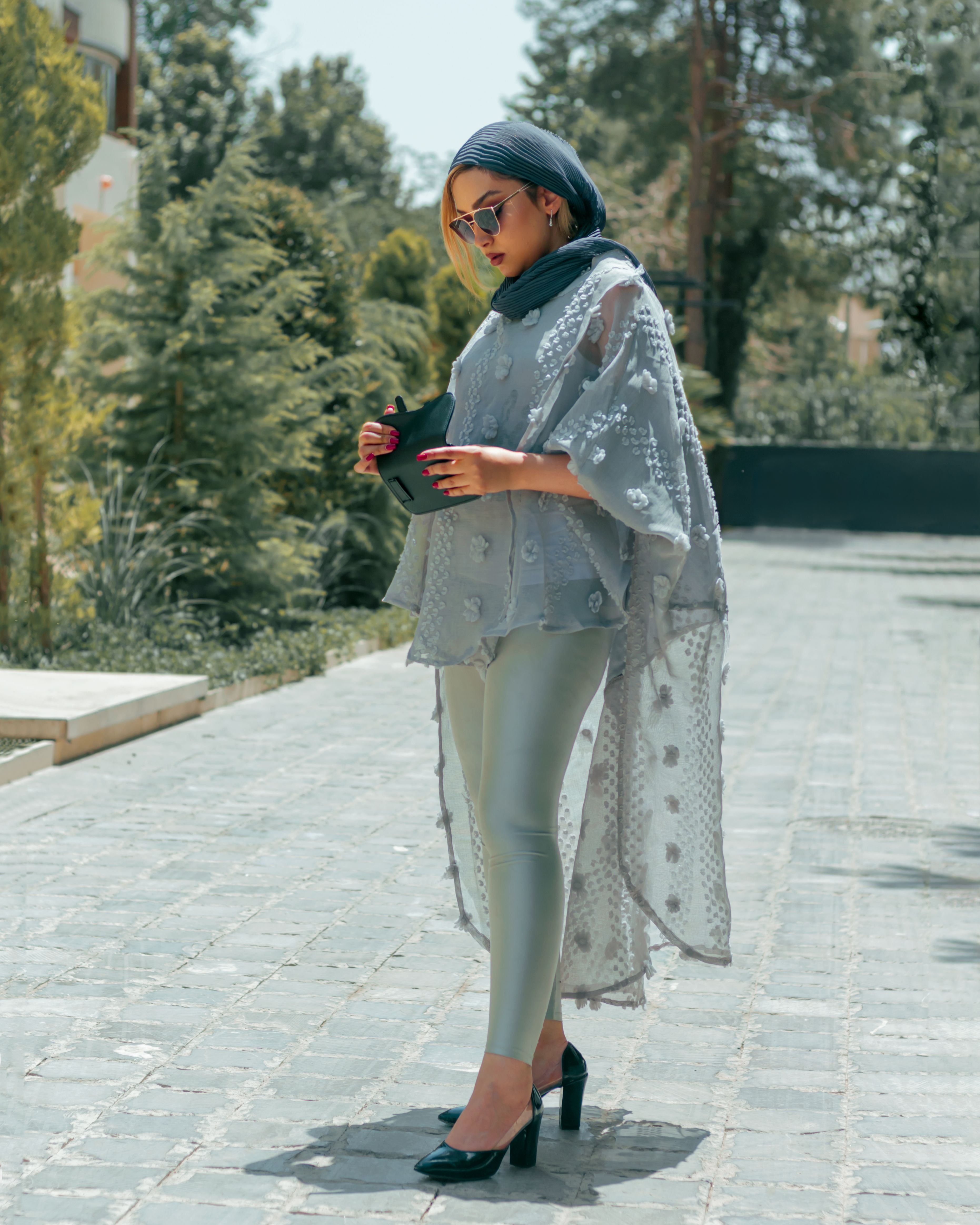 Stylish woman in chic attire enjoys a sunny day outdoors.