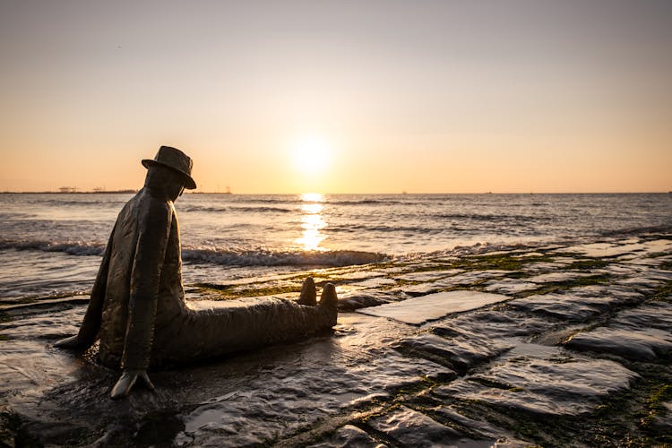 Sunset Over Sea And Man Statue