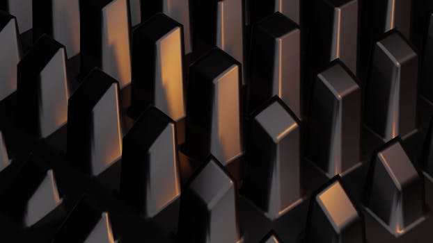 Dark abstract close-up of illuminated geometric metallic shapes forming a pattern.