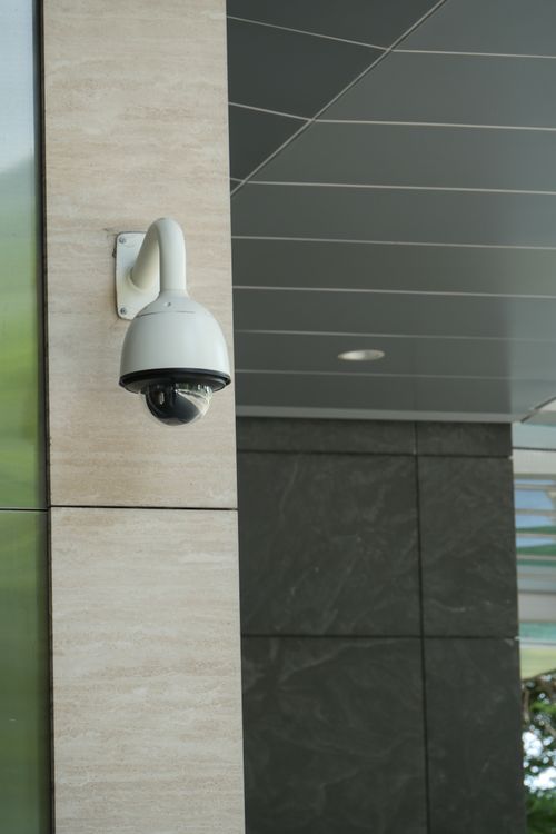 Free Close-up of a mounted security camera on a modern building's exterior. Stock Photo