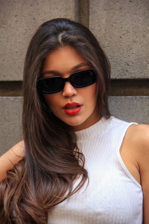 Free Stylish woman with sunglasses posing against a concrete wall in Mexico City. Stock Photo