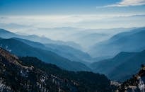 蔚蓝的天空下，雾覆盖的山脉景色壮丽