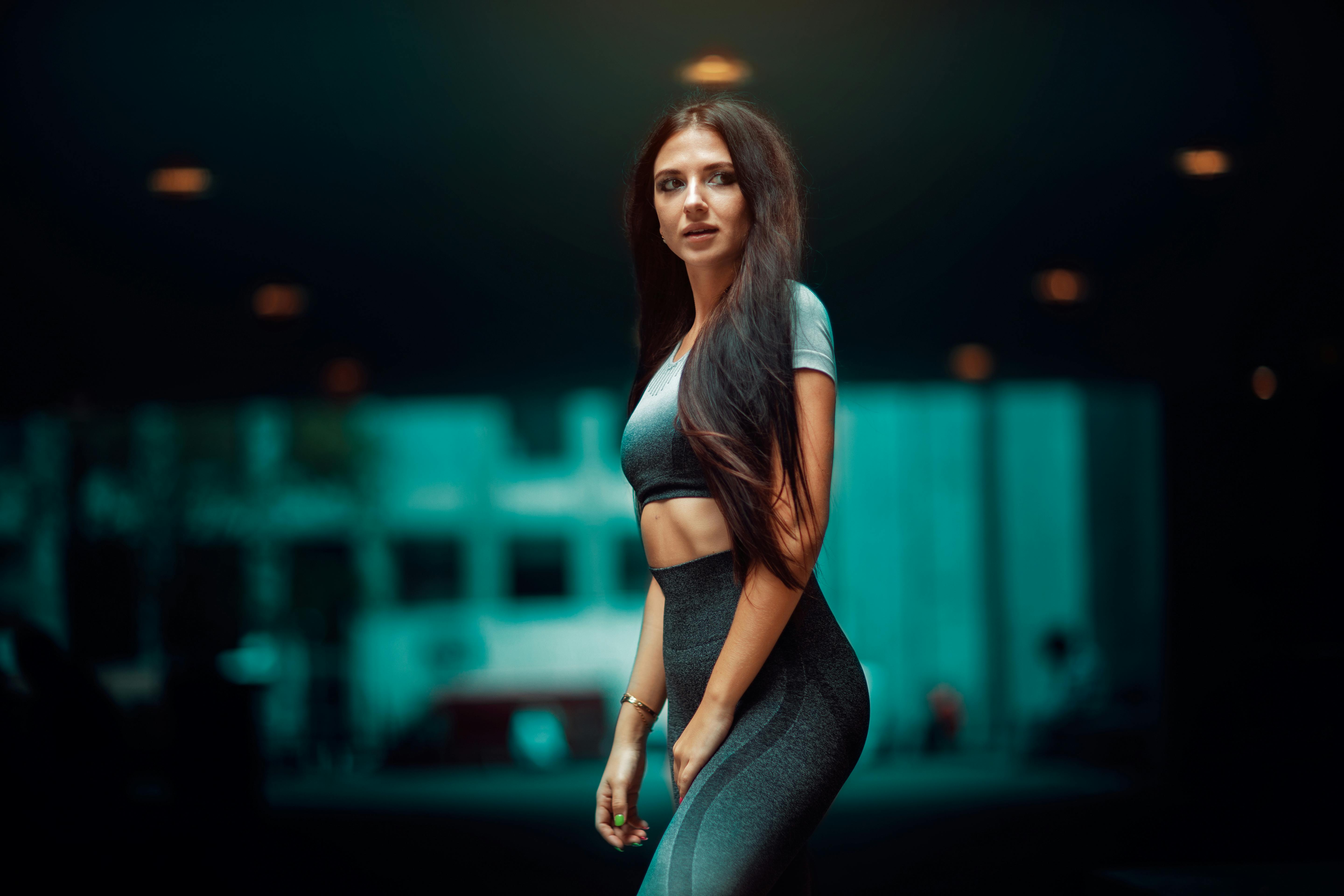 Free Portrait of a brunette woman in casual sportswear on a city street, capturing modern fashion and style. Stock Photo