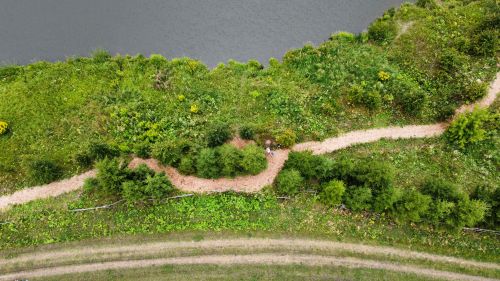 Free Drone shot of a green landscape with a winding path in Dvoryaninovo, Russia. Stock Photo