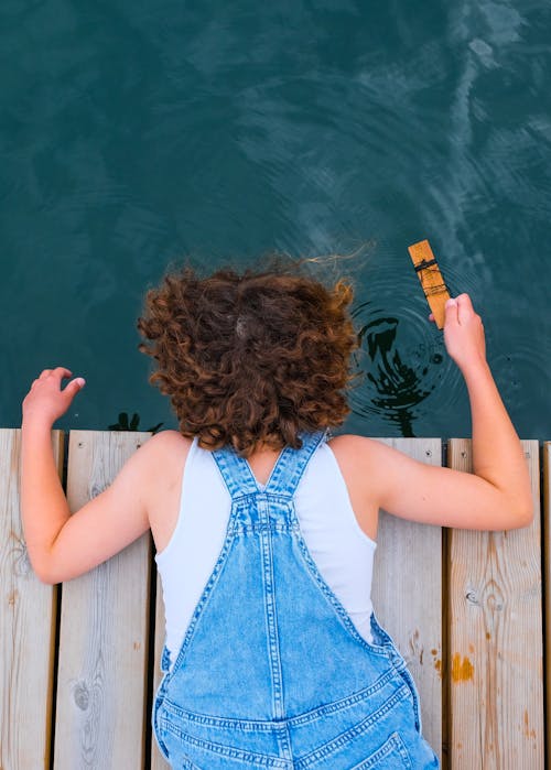 Free Woman Lying Down on Wooden Pier Stock Photo