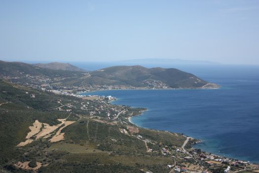 Aerial view of a serene coastline with blue sea and hills, perfect for nature enthusiasts.
