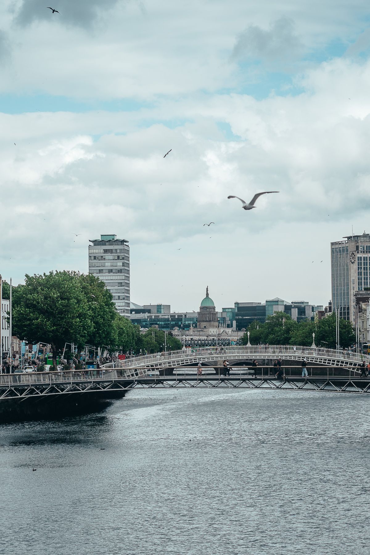 A Ponte Ha'penny sobre o rio Liffey em Dublin com a cupula verde da Custom House ao fundo