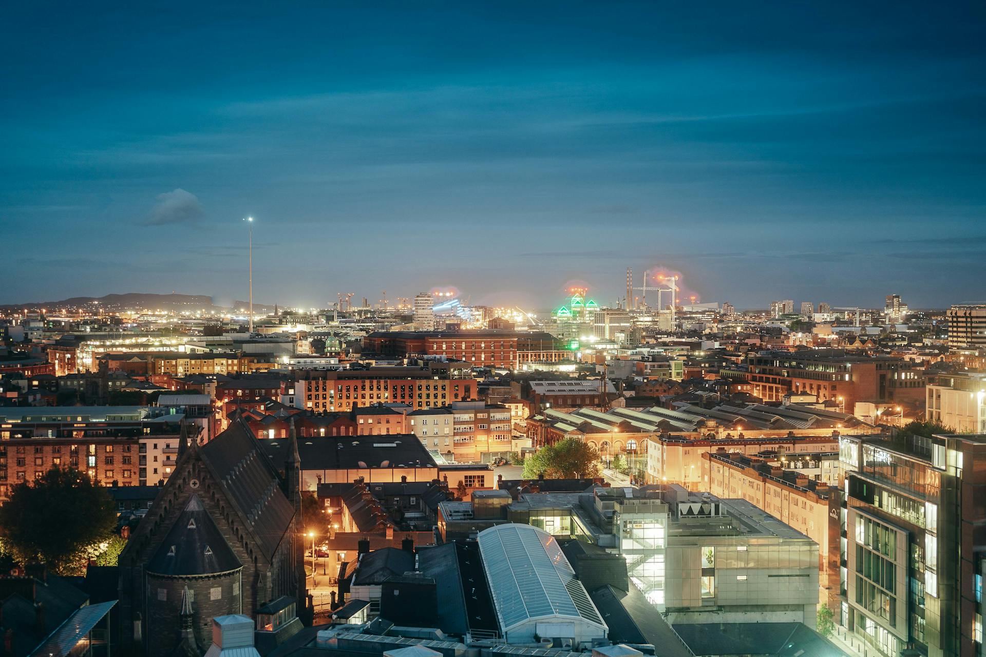 Stunning aerial view of Dublin cityscape illuminated at night, capturing city lights and urban skyline.
