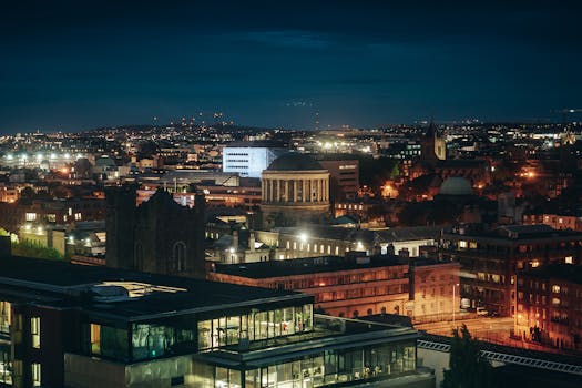 High-angle nighttime shot of Dublin's illuminated cityscape and iconic landmarks.