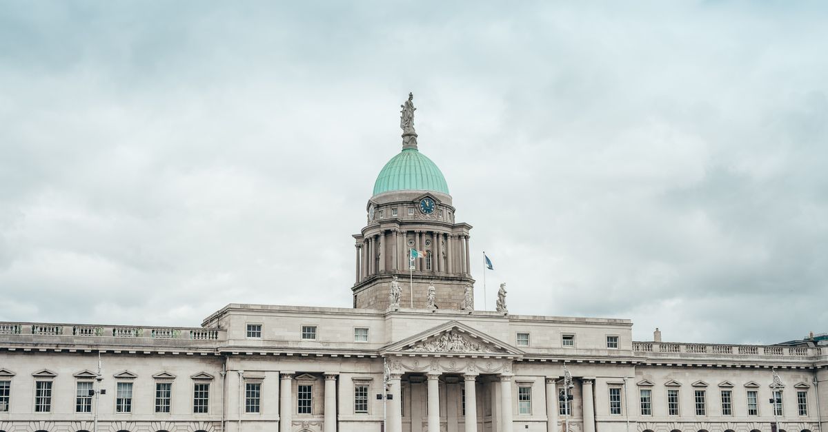 Elegant neoclassical Custom House facade under dramatic cloudy skies in Dublin, Ireland.