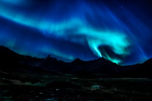 Free Vibrant aurora borealis illuminating the night sky over Myrland mountains in Norway. Stock Photo