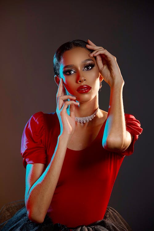 A Beautiful Woman in Red Shirt Posing while Wearing a Silver Necklace