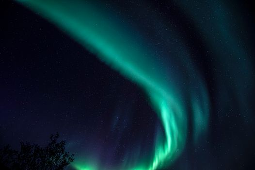 Breathtaking view of aurora borealis over Sund, Nordland, Norway's starry night sky.