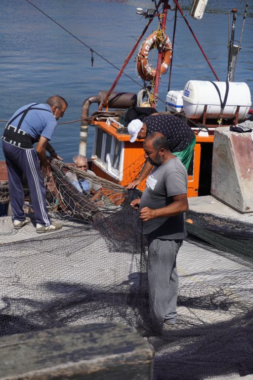 Free Fishermen handling nets on a boat in Mar del Plata, Argentina under bright daylight. Stock Photo