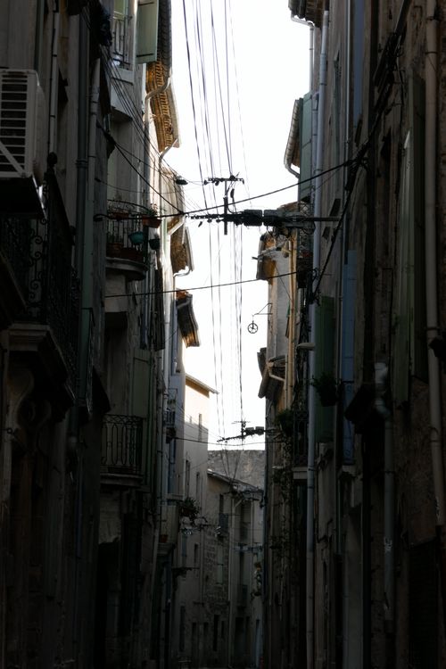 Free Moody urban alleyway captured with intricate overhead lines and historic buildings. Stock Photo