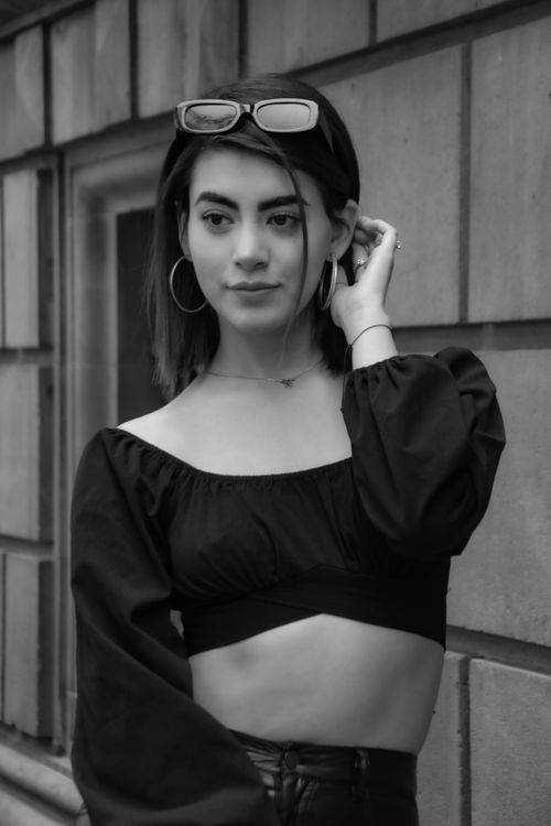 Free Monochrome photo of a stylish woman posing outside in a black crop top. Stock Photo