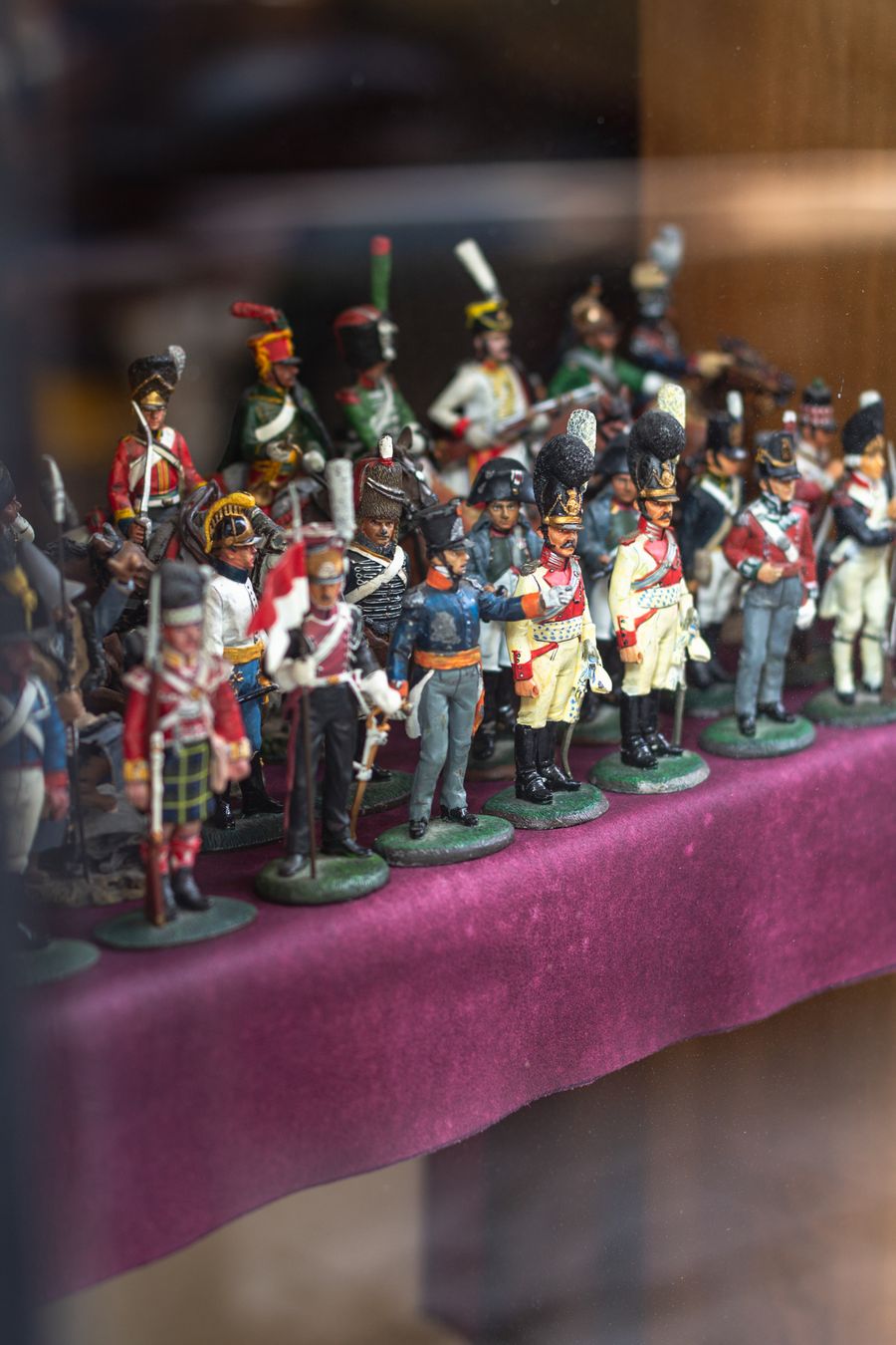 Finished painted figures lined up in a display cabinet