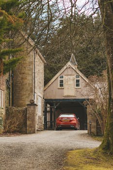 在威尔士乡村的一座古色古香的石房子里，一辆红色汽车停在车库中