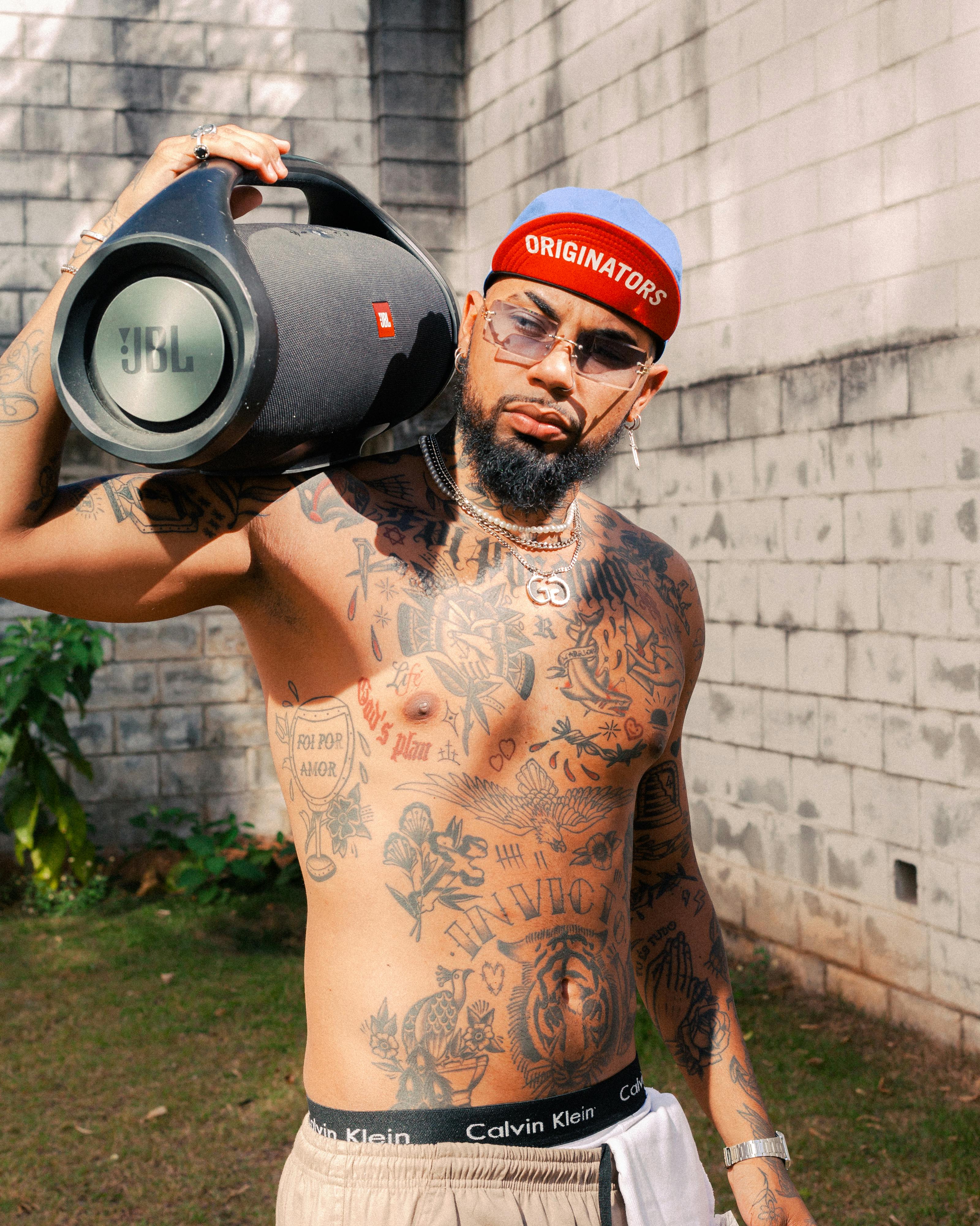 man with tattoos holding speaker