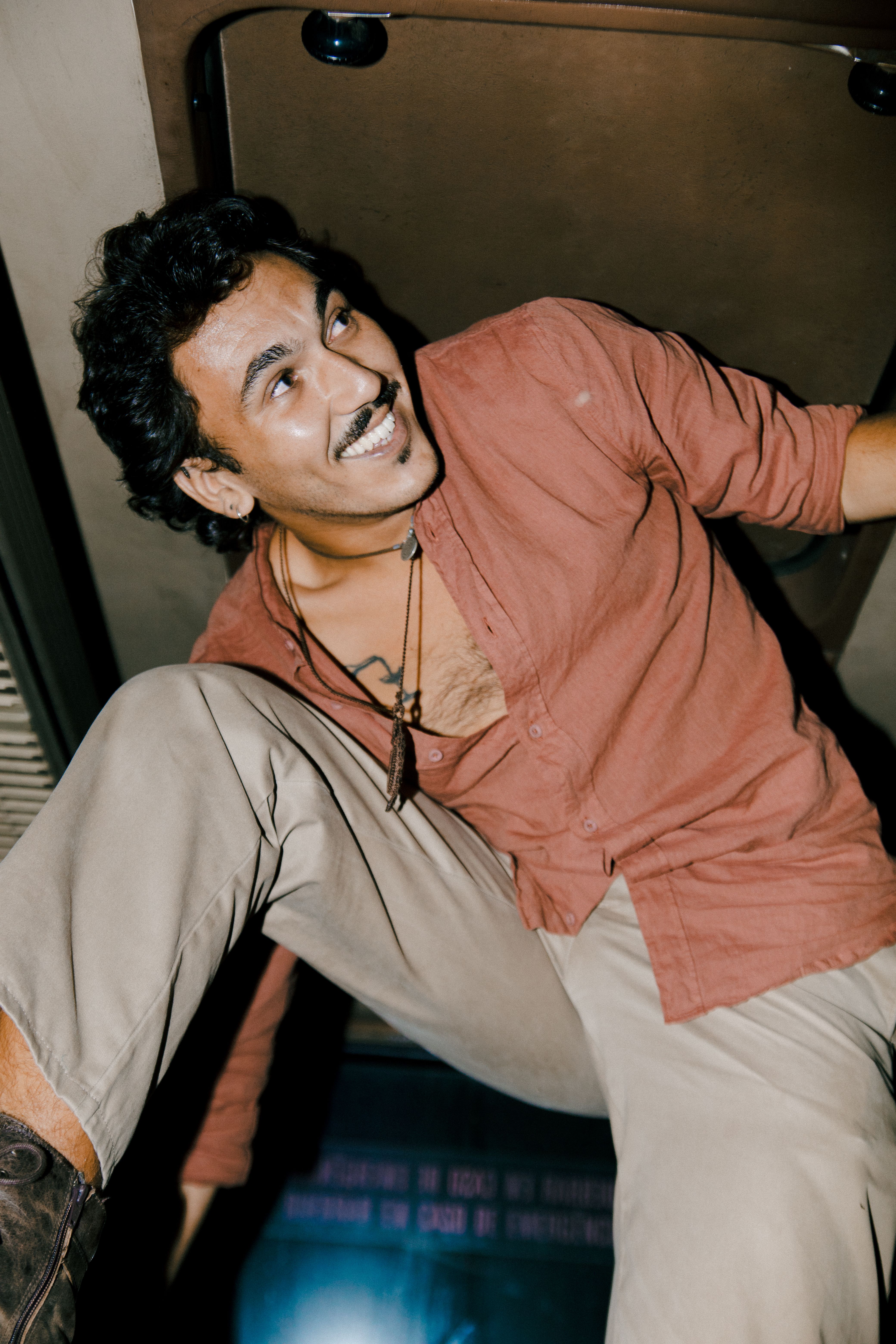Cheerful man with stubble smiling inside a vehicle, captured in a dynamic low angle shot.