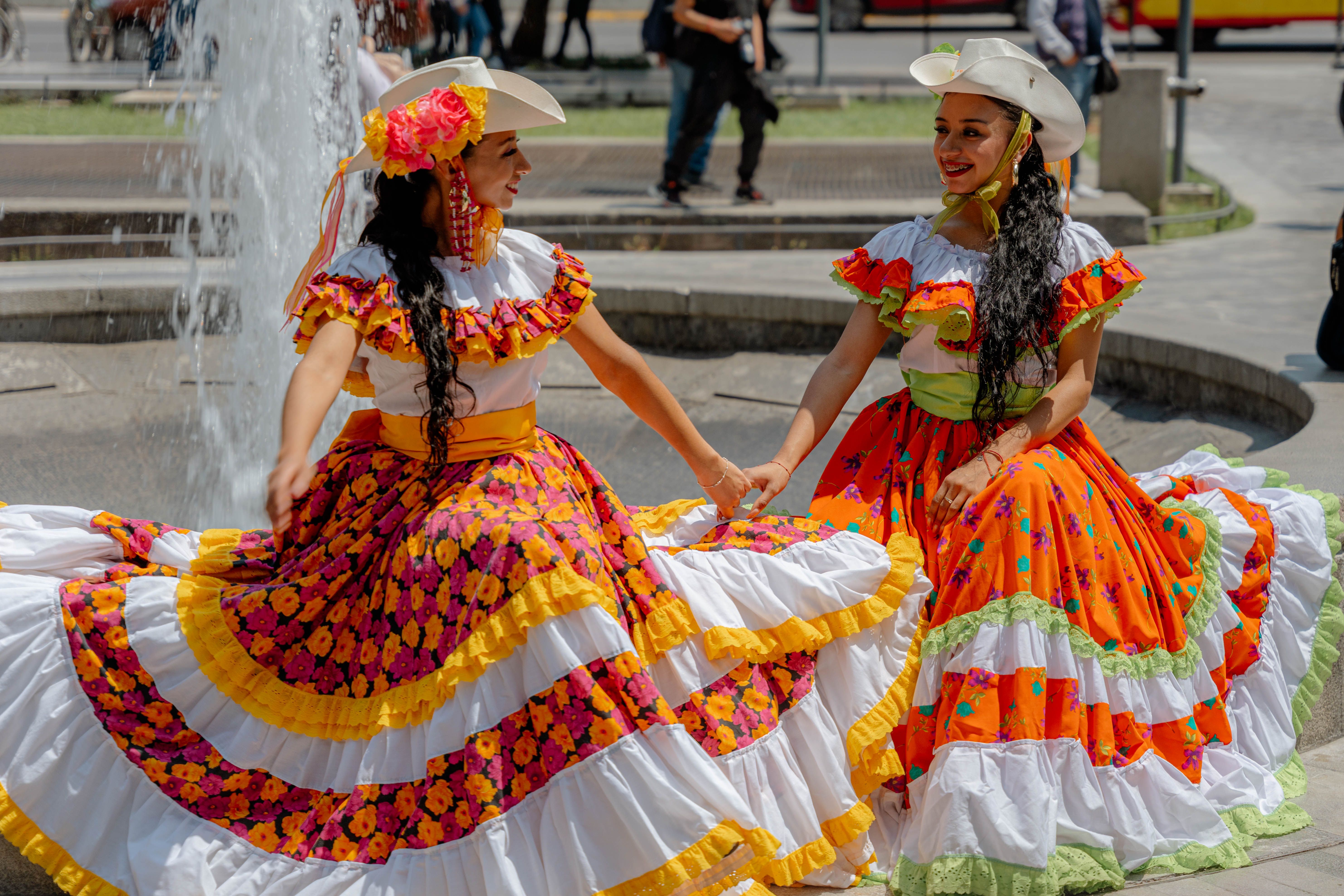Smiling Women Dancing in Traditional Clothing · Free Stock Photo