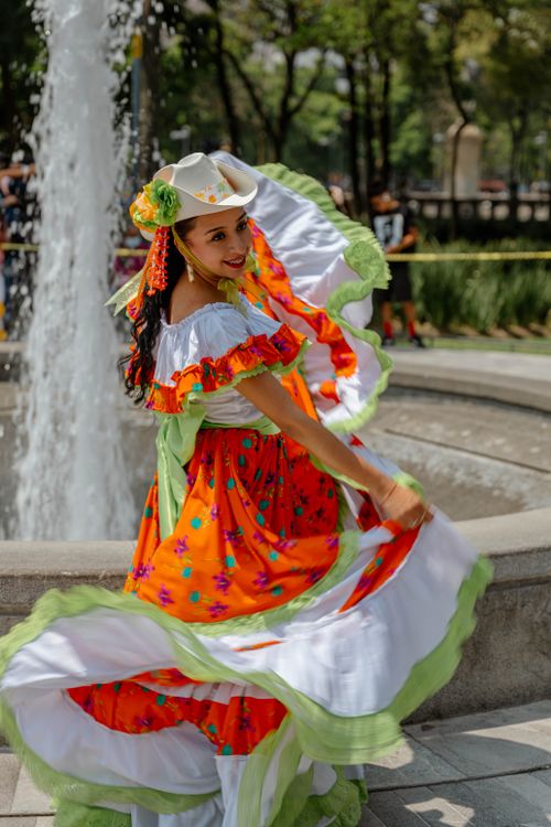Free Colorful Mexican dancer in traditional attire spinning in a lively outdoor performance. Stock Photo