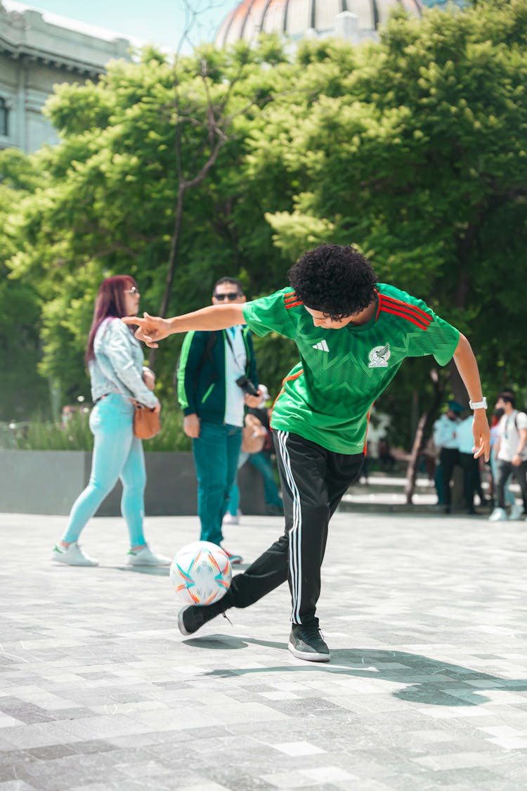 A Man In A Green Shirt Playing Soccer